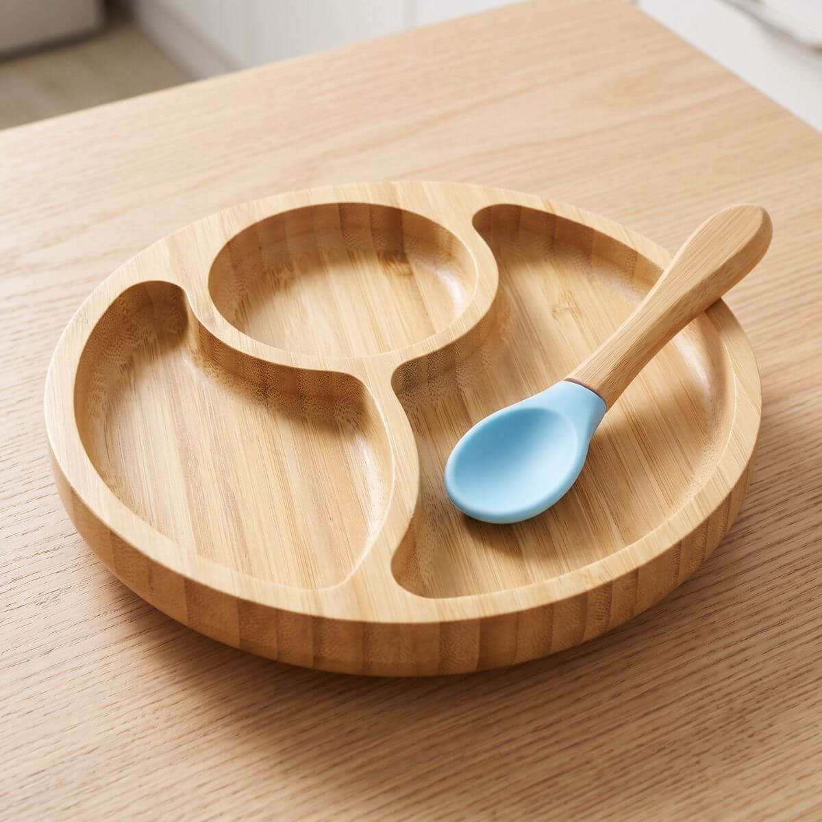 Bamboo divided plate with the silicone-tipped spoon resting on the plate.